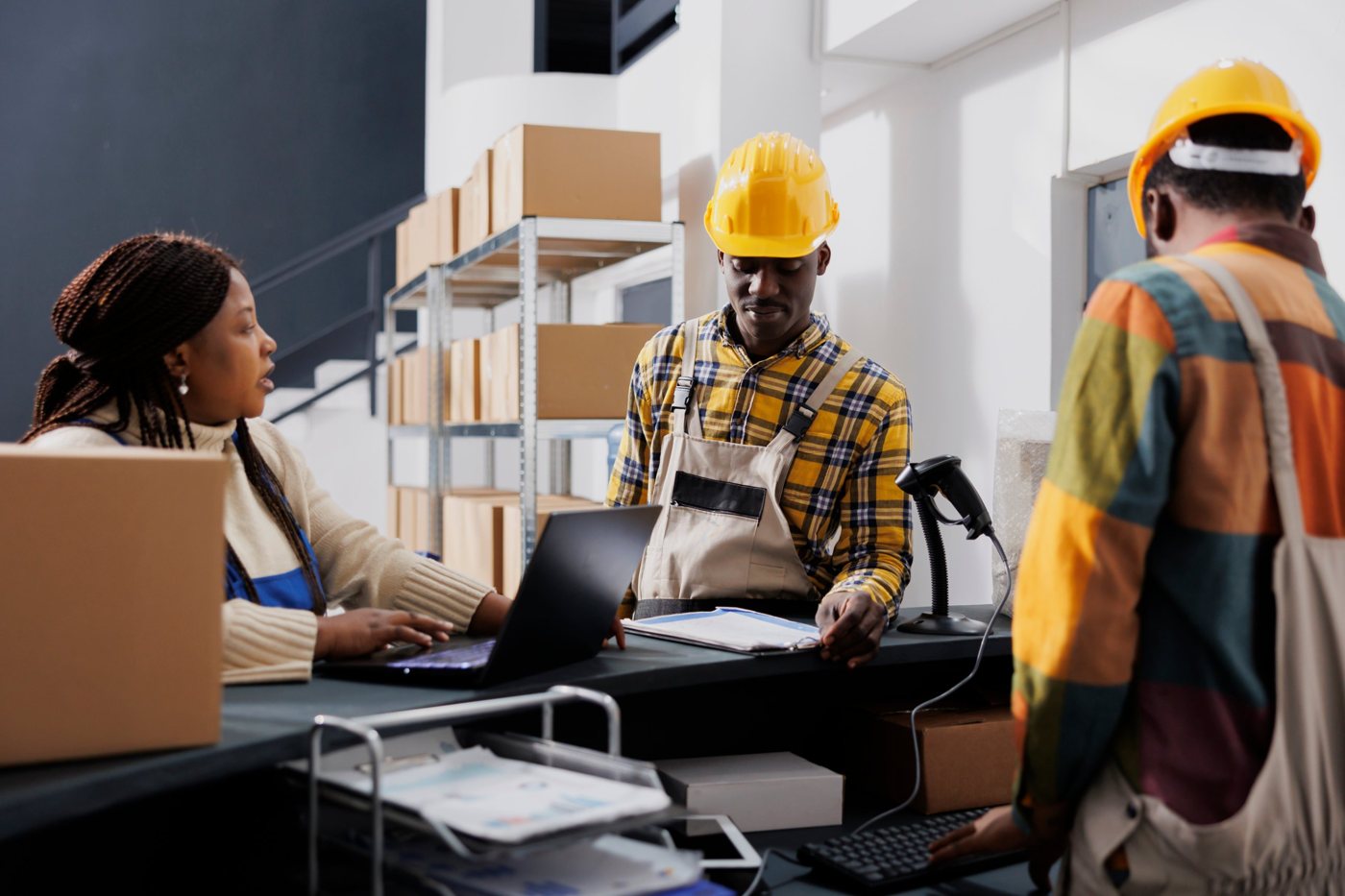 Staff at a shipping counter with a laptop and barcode scanner